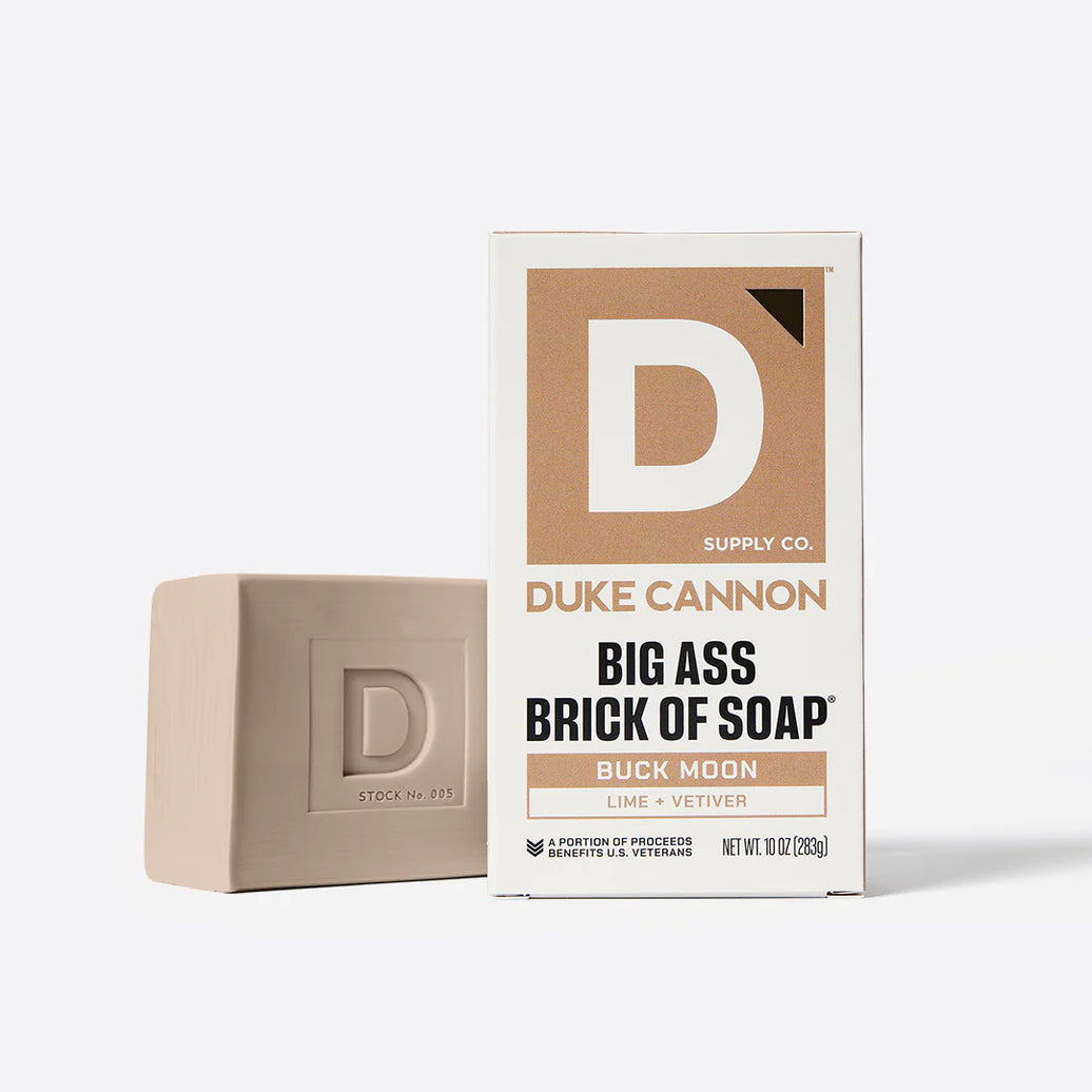 Bar of soap next to its packaging on a white background