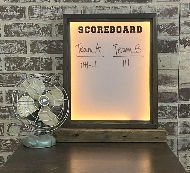 A framed scoreboard with a black finish, displaying 'TEAM A' and 'TEAM B' with point totals, using an LED backlight.