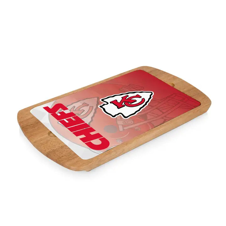 Wooden cutting board with a glass top with the Kansas City Chiefs logo on a white background.