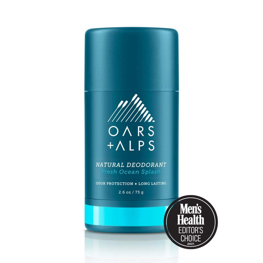 A stick deodorant with blue packaging labeled 'OARS + ALPS NATURAL DEODORANT fresh ocean splash'. There is a Men's Health Editors Choice badge displayed in front of the product.