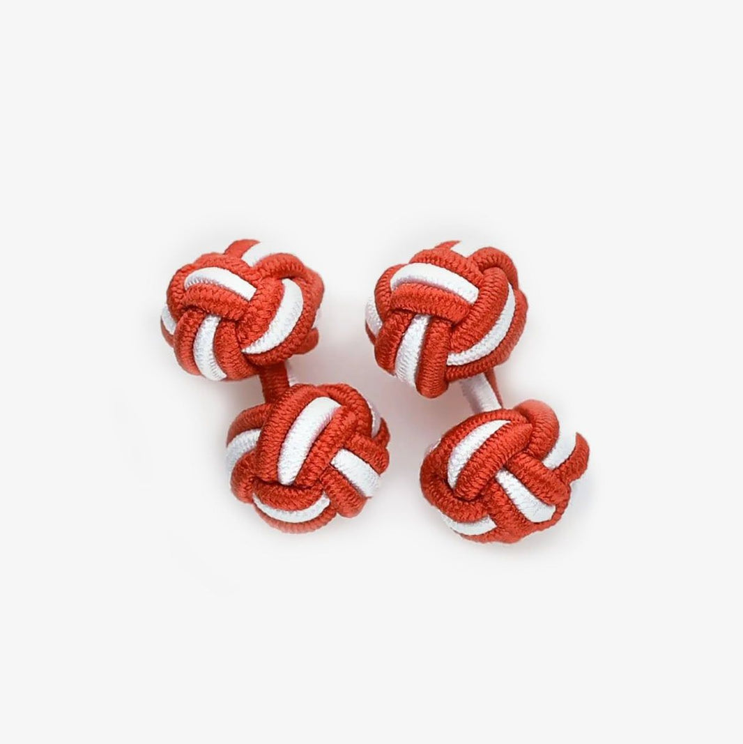Two red and white knot cufflinks on a white background
