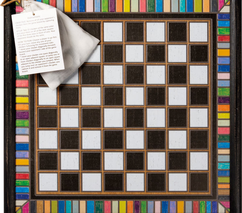 Checkered board with colorful border and bag with pieces and instruction paper attached.