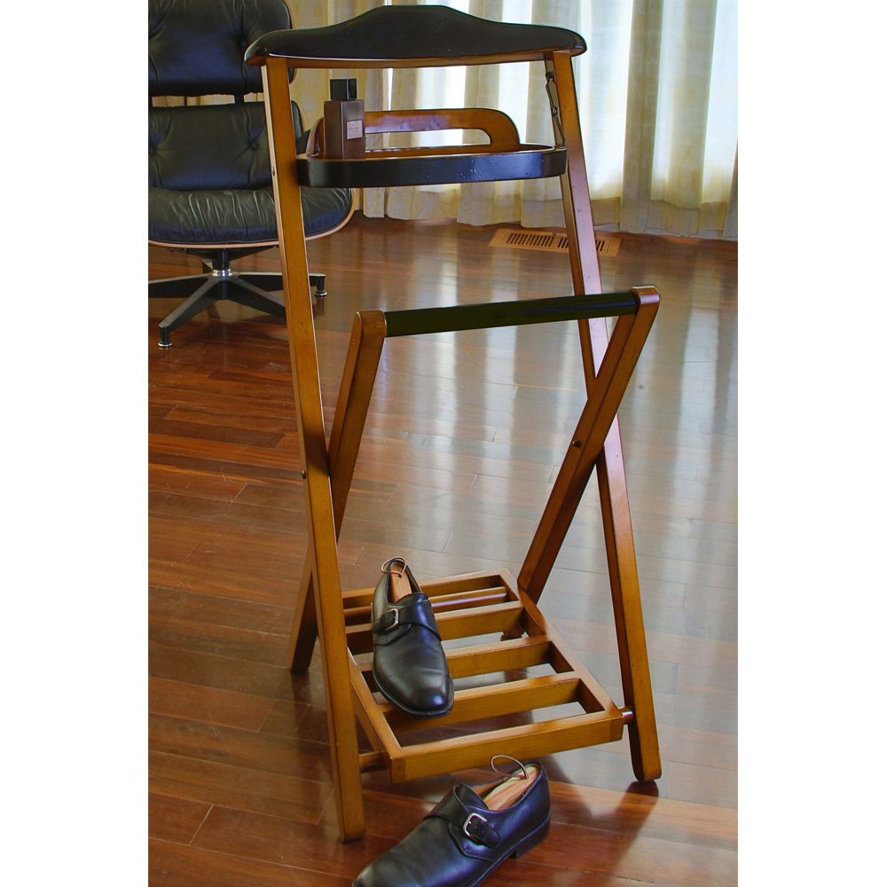 Wooden clothing and shoe rack with shoes on a wooden floor
