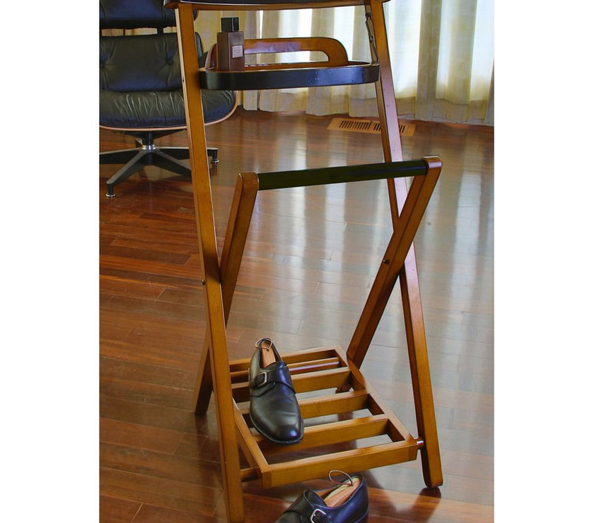 Wooden clothing and shoe rack with shoes on a wooden floor