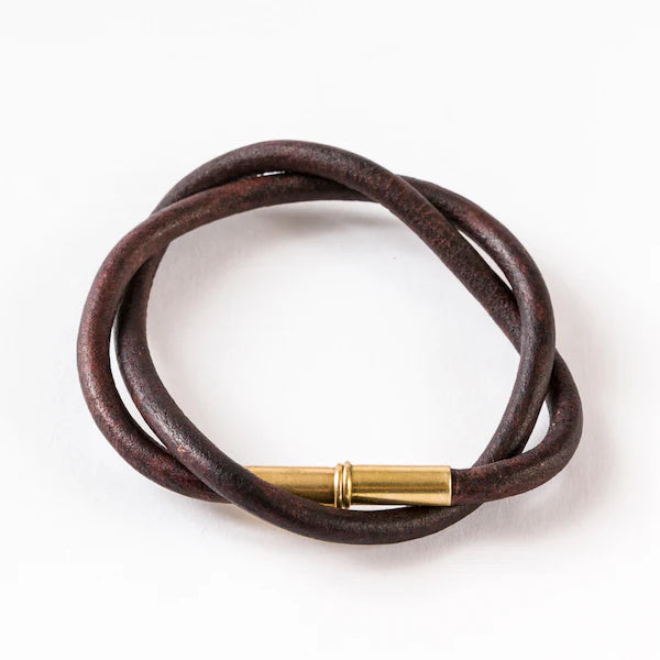 Brown leather bracelet with a gold clasp on a white background