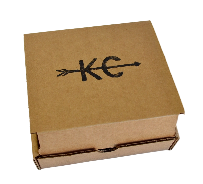 A brown box with 'KC' and an arrow through the letters; the packaging for the KC Arrow flask.