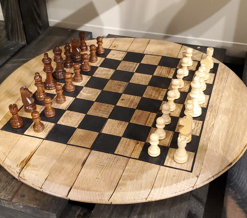 Wooden chessboard with black and white chess pieces on a wooden table