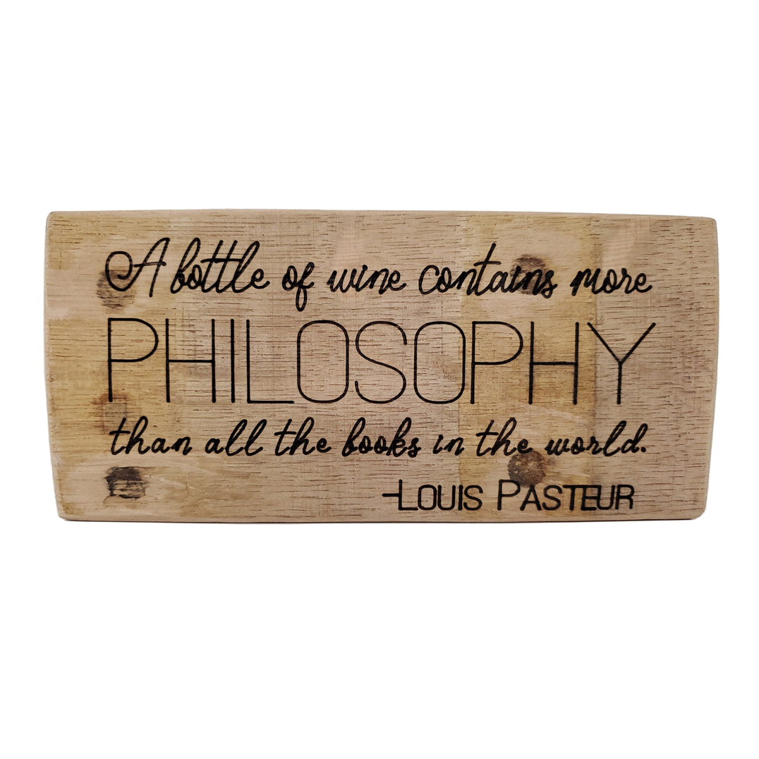 Wooden sign with engraved Louis Pasteur quote on a white background