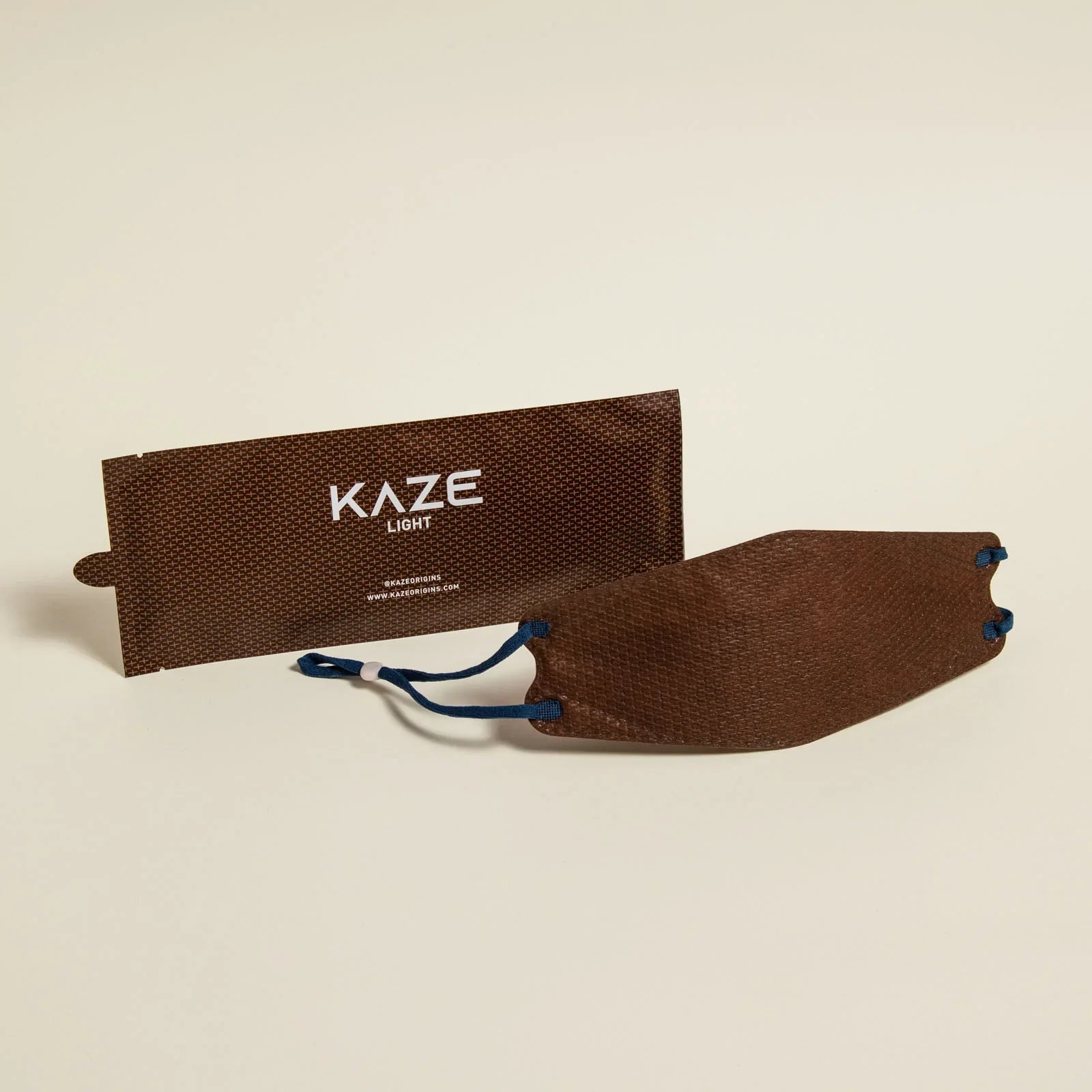 Brown Kaze light packaging with a drawstring on a beige background