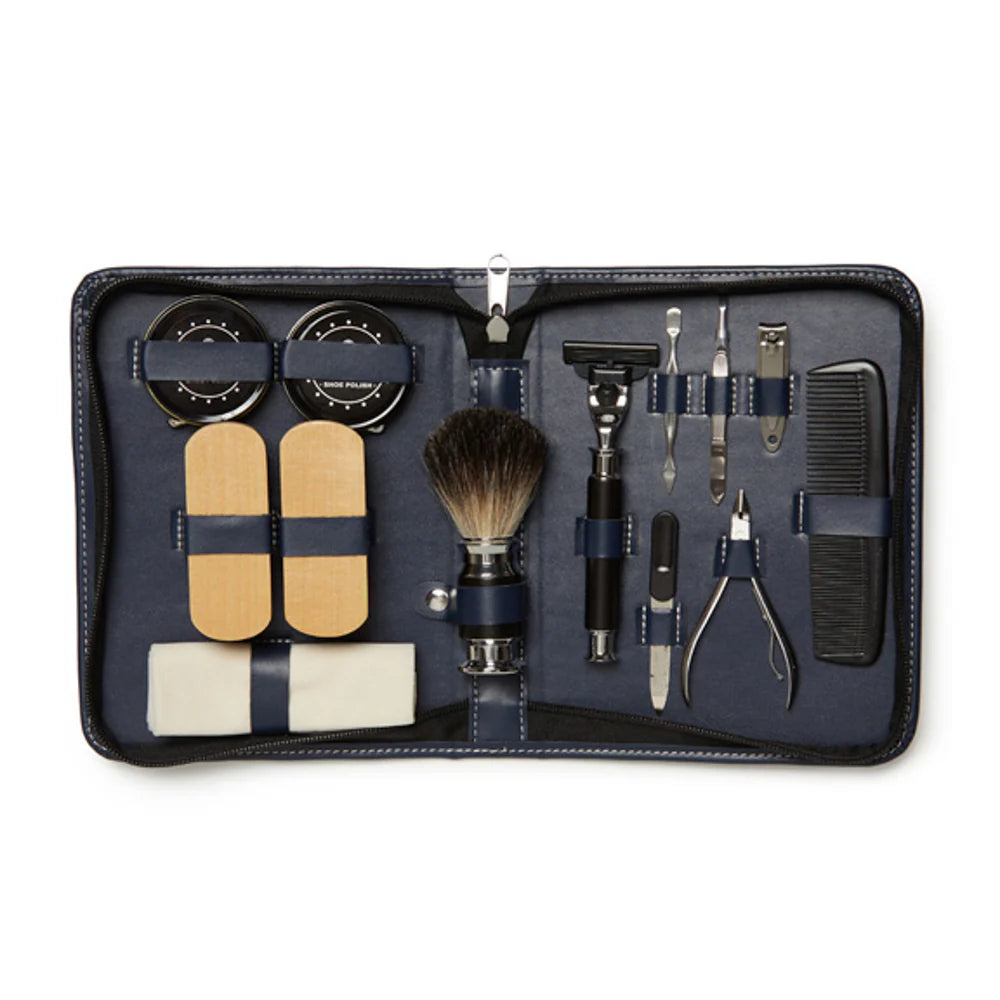 Open black leather case containing a set of grooming and shoe care tools on a white background