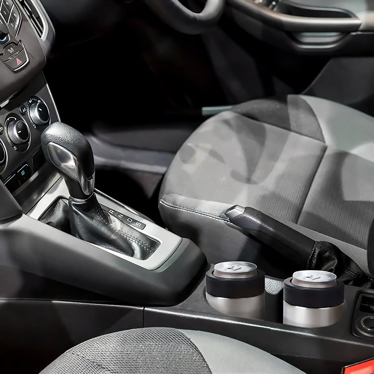 Car interior with gear shift and cup holders that contain drinks in stainless steel can holders.