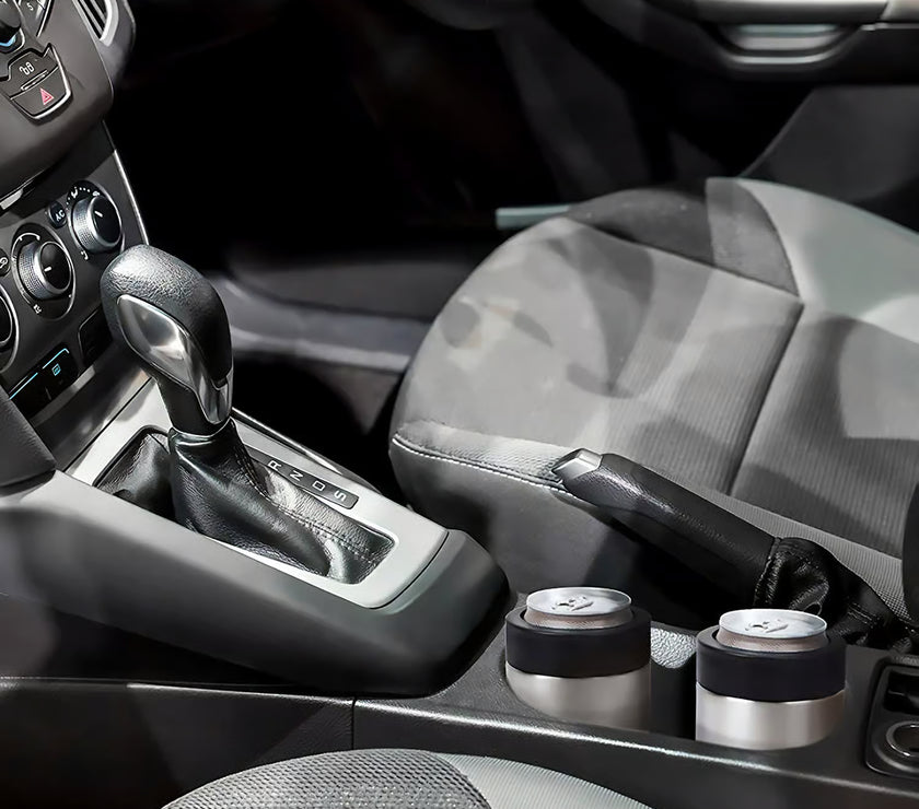 Car interior with gear shift and cup holders that contain drinks in stainless steel can holders.