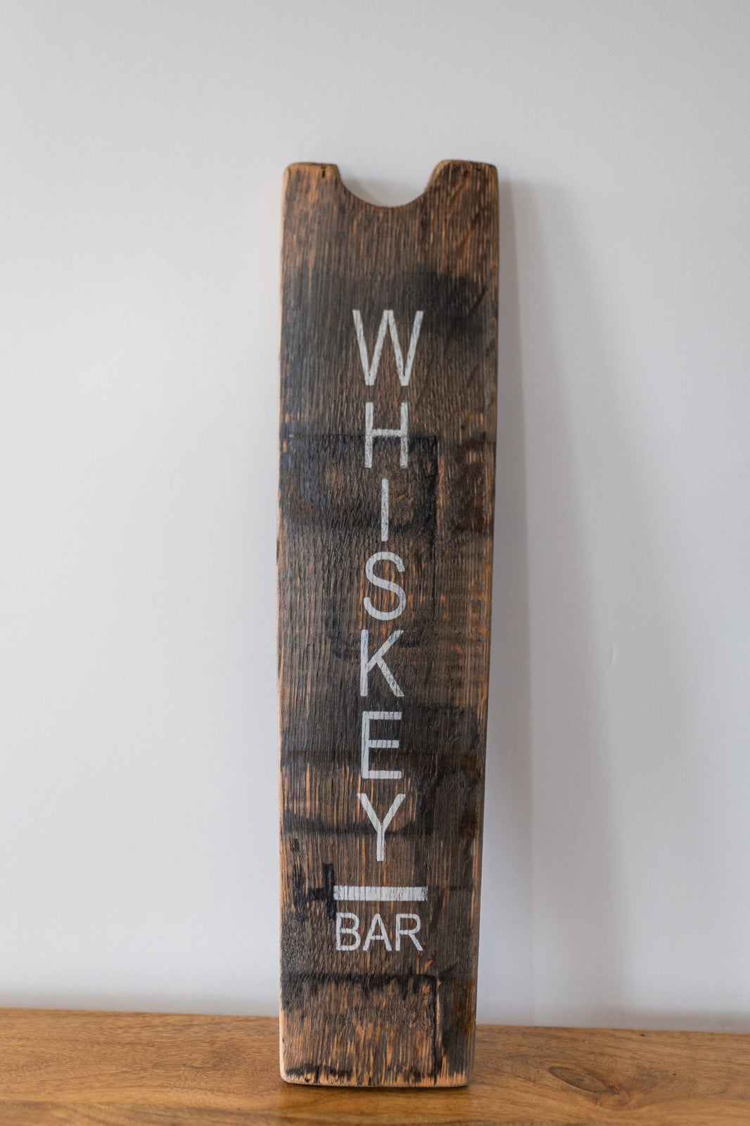 Wooden sign with 'WHISKEY BAR' text on a white background
