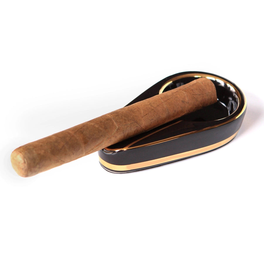 A cigar resting in a single cigar ashtray.