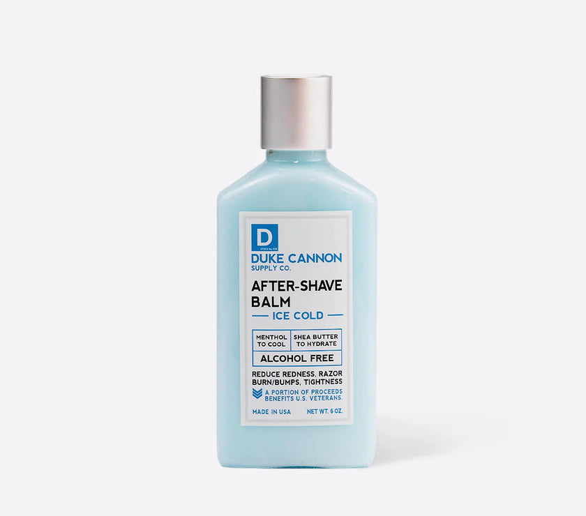 A bottle of Duke Cannon Cooling After-Shave Balm with menthol, aloe, shea butter, and allantoin, in a light blue color, with text indicating it is alcohol-free.