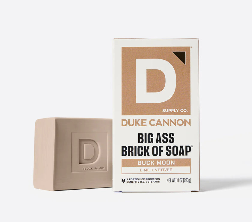 Bar of soap next to its packaging on a white background