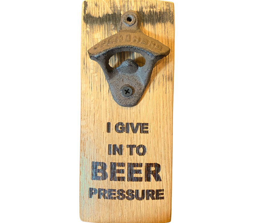 Barrel stave bottle opener with cast iron cap opener and engraved text "I give in to beer pressure" on it