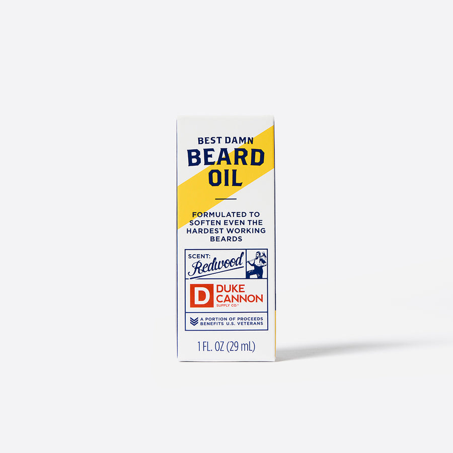 A bottle of Duke Cannon Beard Oil with branding and product information displayed on the front.