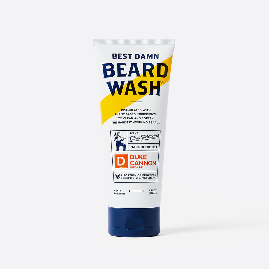 A tube of Duke Cannon Best Damn Beard Wash with a blue and yellow label, white background.