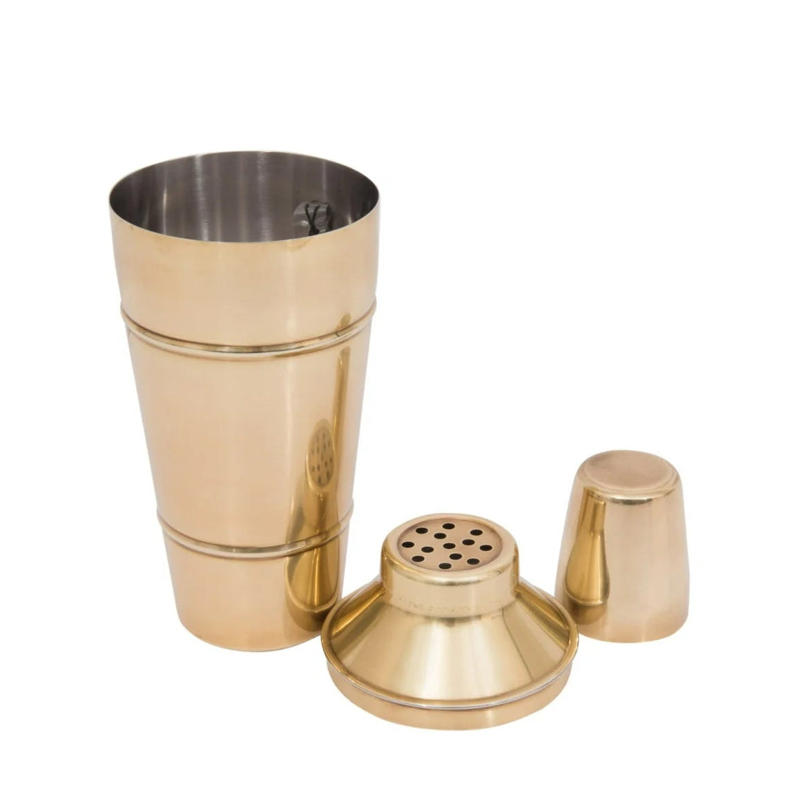 Brass finished cocktail shaker with components on a white background