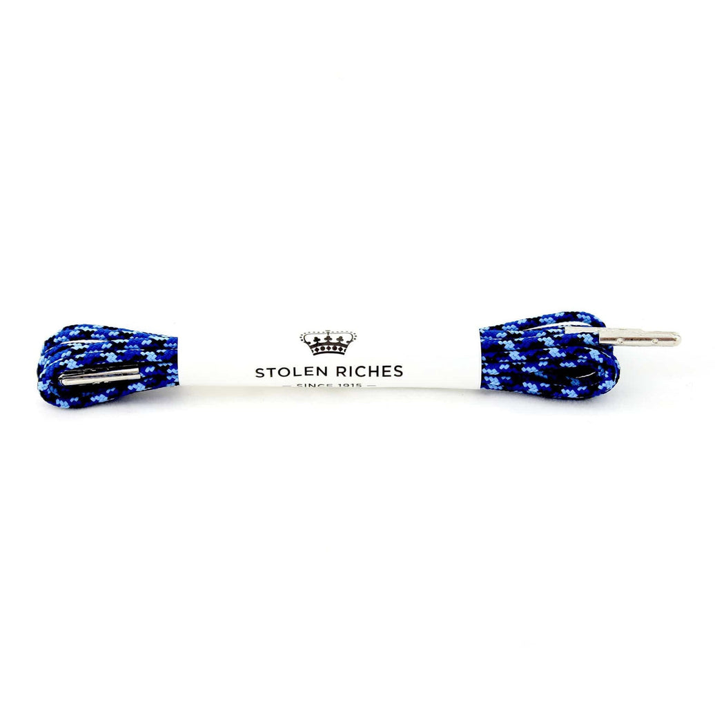 A pair of camouflage blue dress shoelaces with silver tips and the brand name 'Stolen Riches' displayed on the laces.
