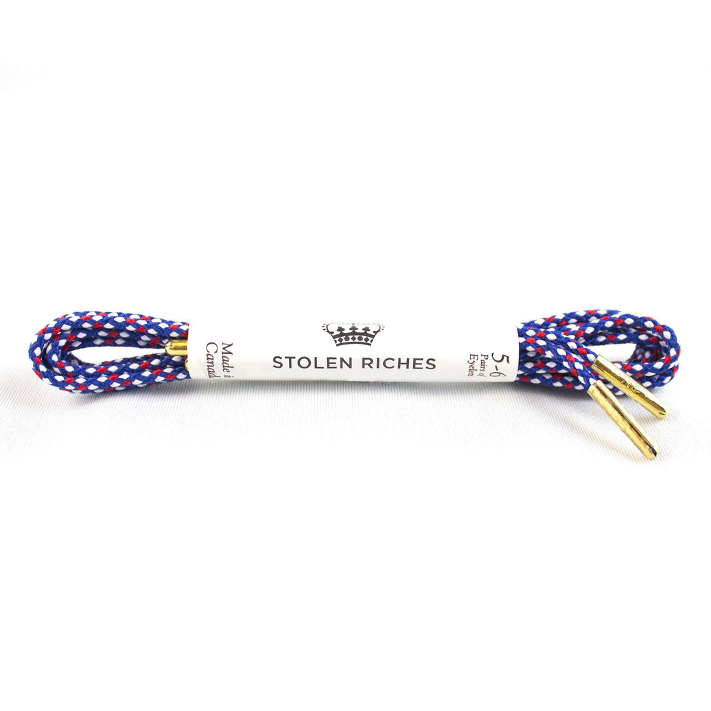 A pair of red, white, and blue dress shoelaces with metal tips and the brand 'Stolen Riches' labeled on the packaging.