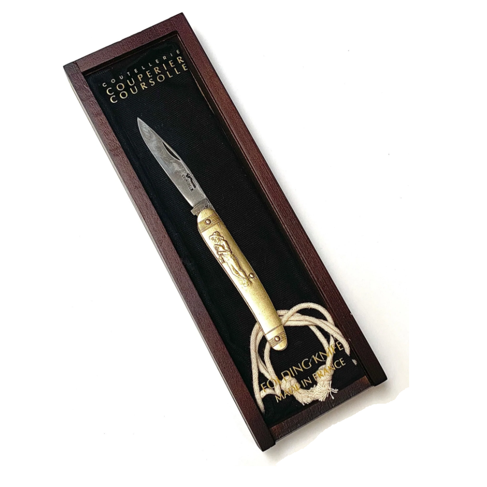 Knife with gold handle and decorative elements in a wooden box, featuring the brand 'Couteau de Courselle'.