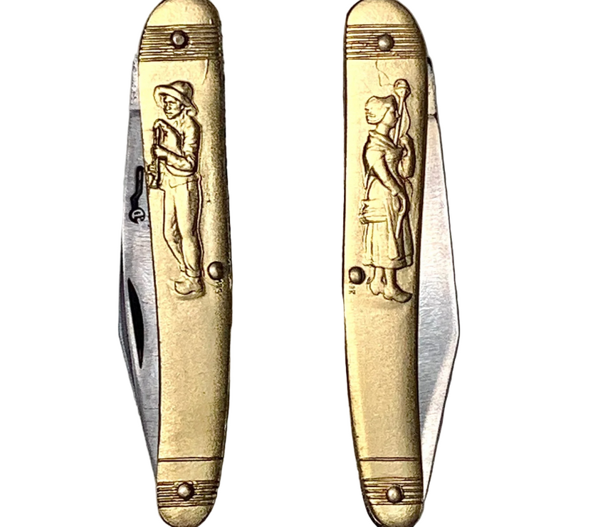 Two gold pocket knives with engraved figures on a white background