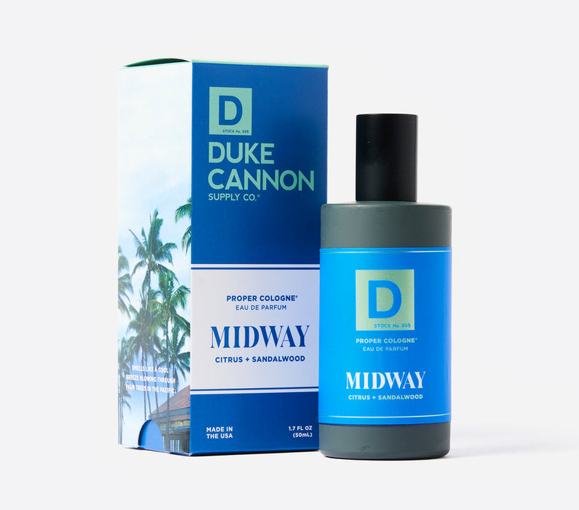 A product image featuring a bottle of Duke Cannon Proper Cologne in the scent 'Midway', accompanied by its packaging box. The cologne bottle is blue with white text, and the box has a palm tree illustration.