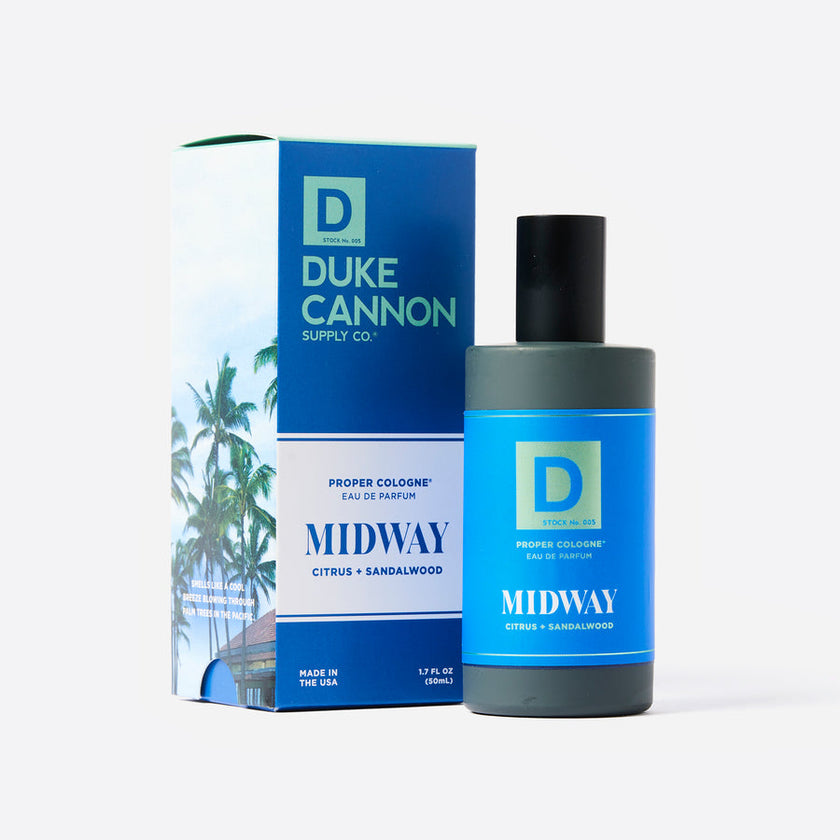 A product image featuring a bottle of Duke Cannon Proper Cologne in the scent 'Midway', accompanied by its packaging box. The cologne bottle is blue with white text, and the box has a palm tree illustration.
