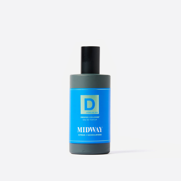 A bottle of Duke Cannon Proper Cologne in the scent Midway with a blue label.