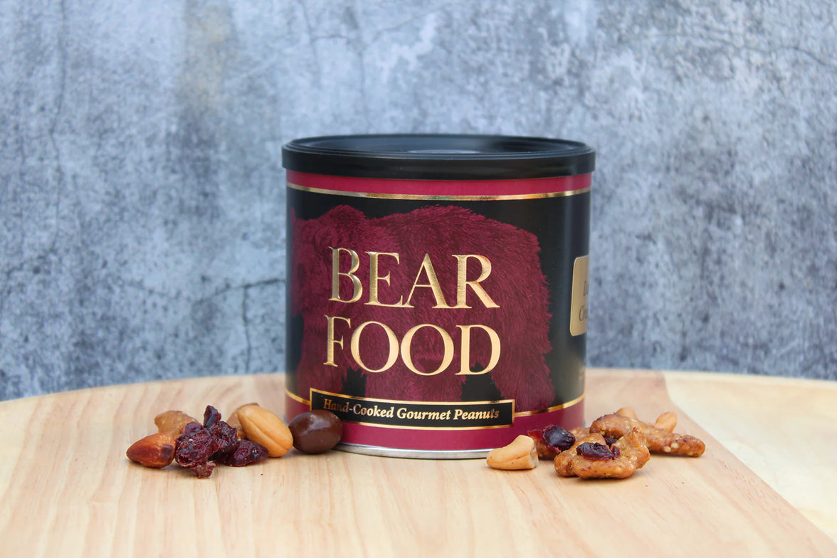 Canister labeled 'Bear Food' with nuts and dried fruits on a wooden surface