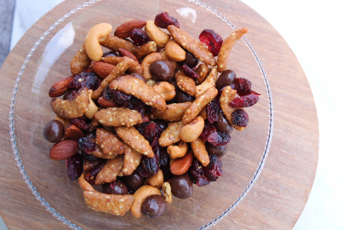 Nuts and dried fruits on a glass plate with a wooden rim