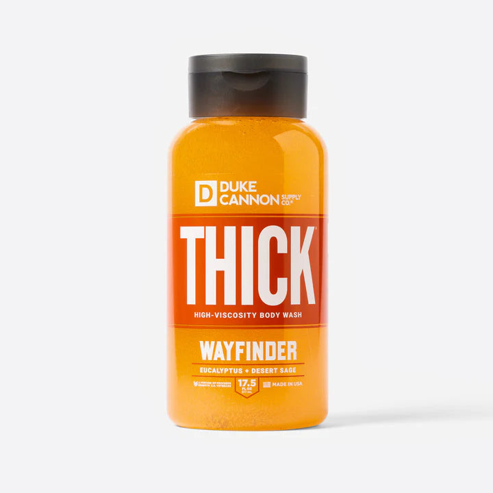 A bottle of Duke Cannon THICK Body Wash - Wayfinder with orange liquid and a black cap.