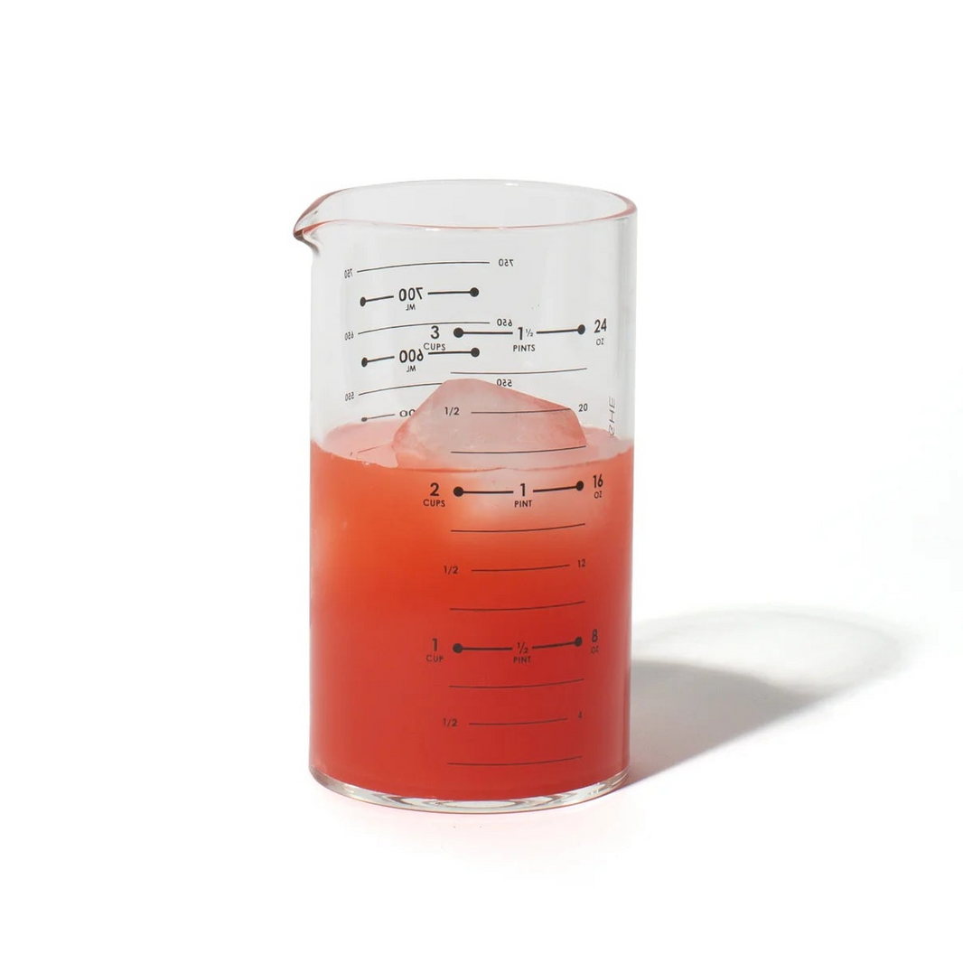 Beaker with red liquid and an ice cube on a white background