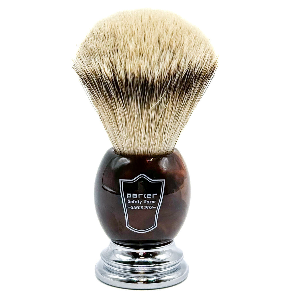 Shaving brush with brown faux horn handle and bristles on a white background