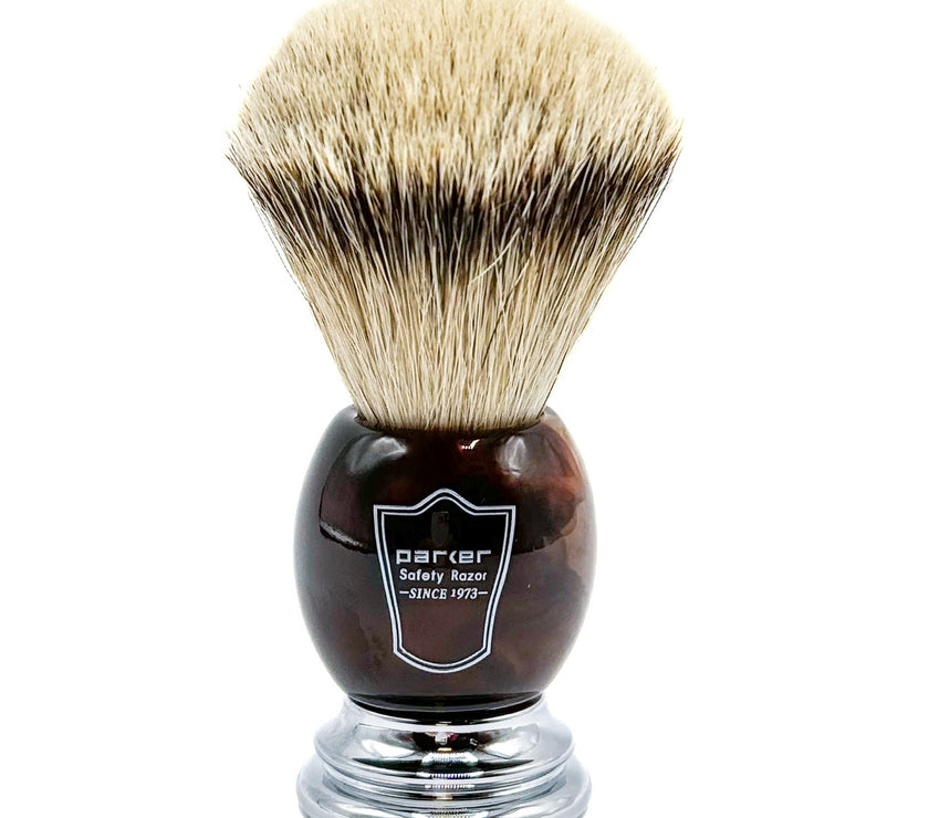 Shaving brush with brown faux horn handle and bristles on a white background