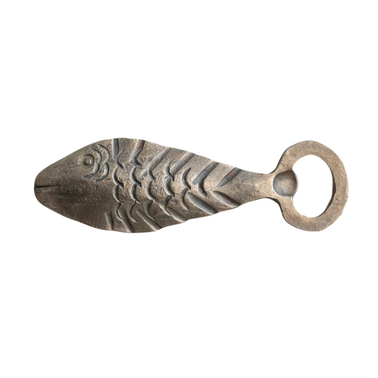 Metal fish-shaped bottle opener on a white background