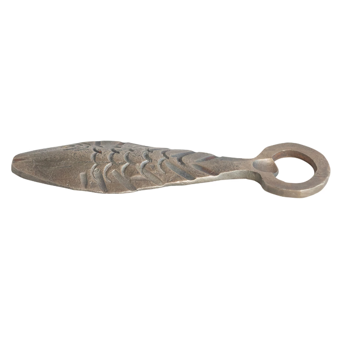 A semi-side view of a metal fish-shaped bottle opener.