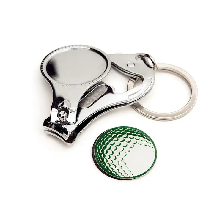 Metallic nail clipper with a green golf ball marker and round keychain on a white background
