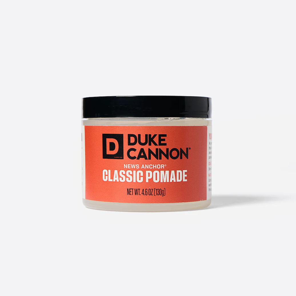 A container of Duke Cannon Classic Pomade with a red label, indicating it is a hair care product.