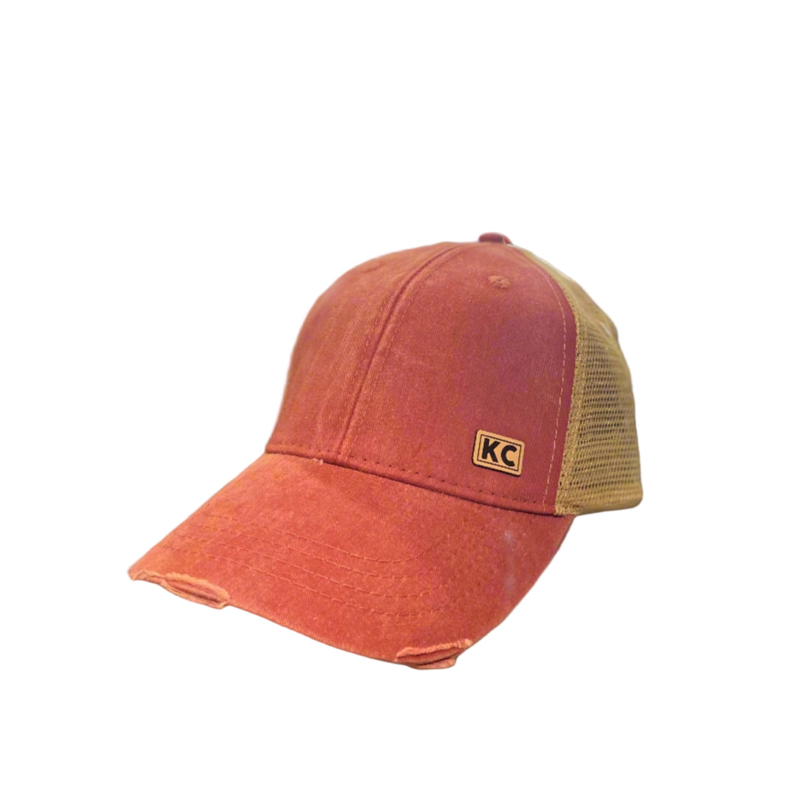 A red vintage-colored ball cap with a KC leather patch on the front.