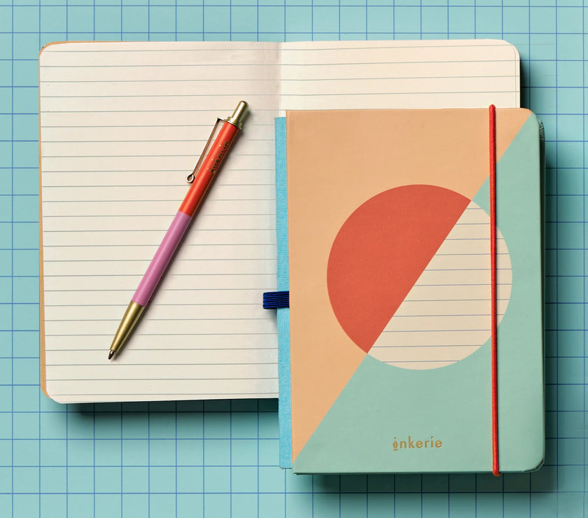 Notebook with geometric design cover and pen on a grid background