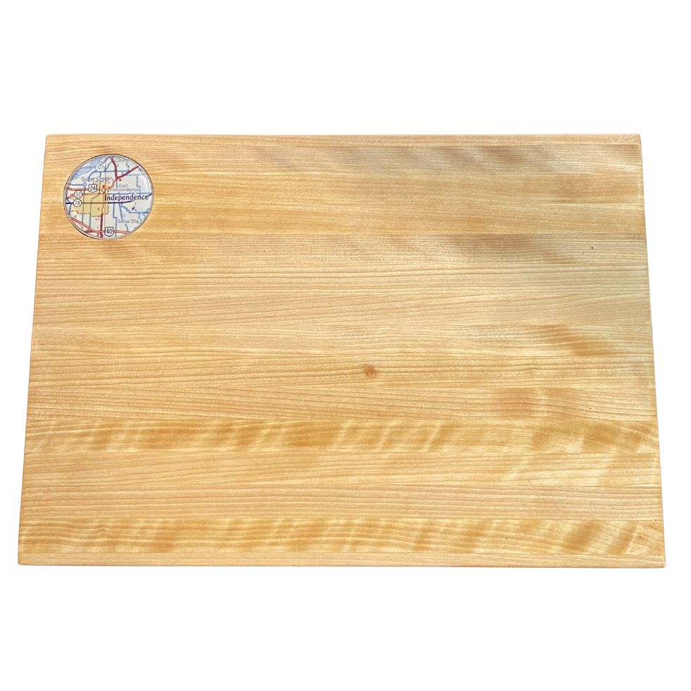 Wooden cutting board with a circular inset featuring a map of Independence, Missouri on a white background