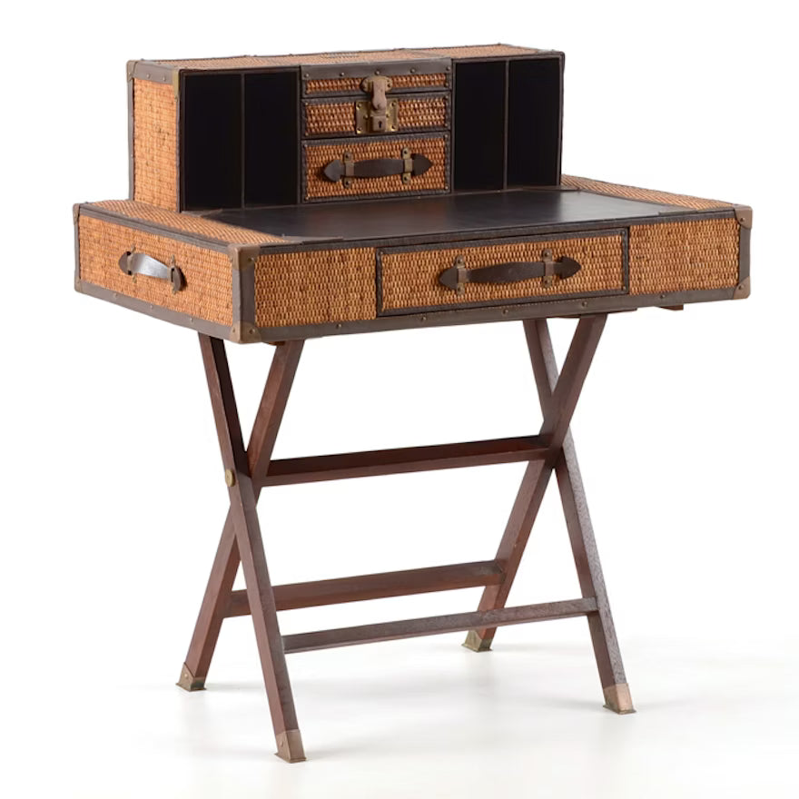A traditional style campaign desk with a wicker and leather surface, and wooden legs.