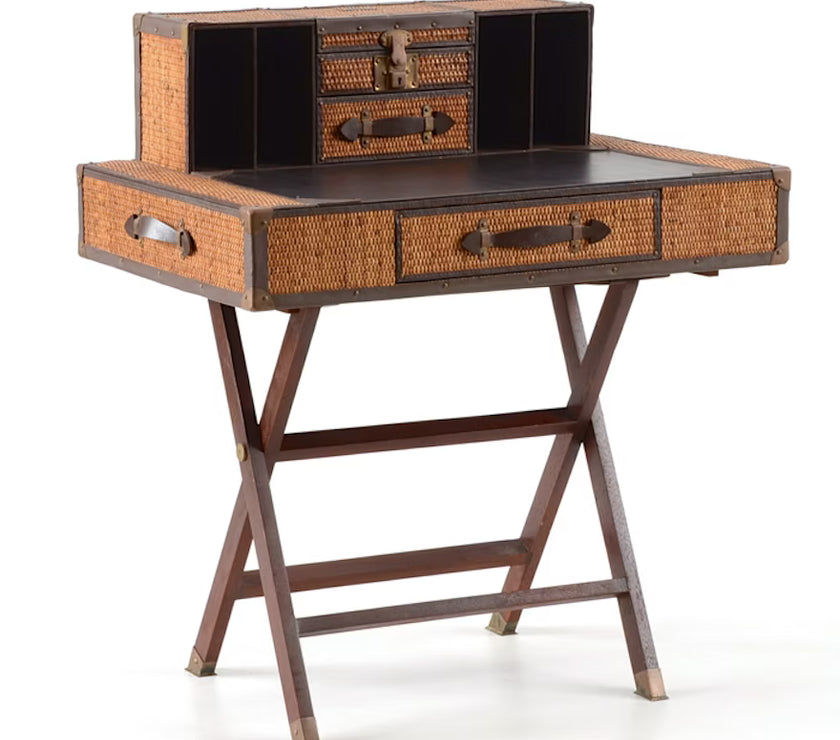 A traditional style campaign desk with a wicker and leather surface, and wooden legs.