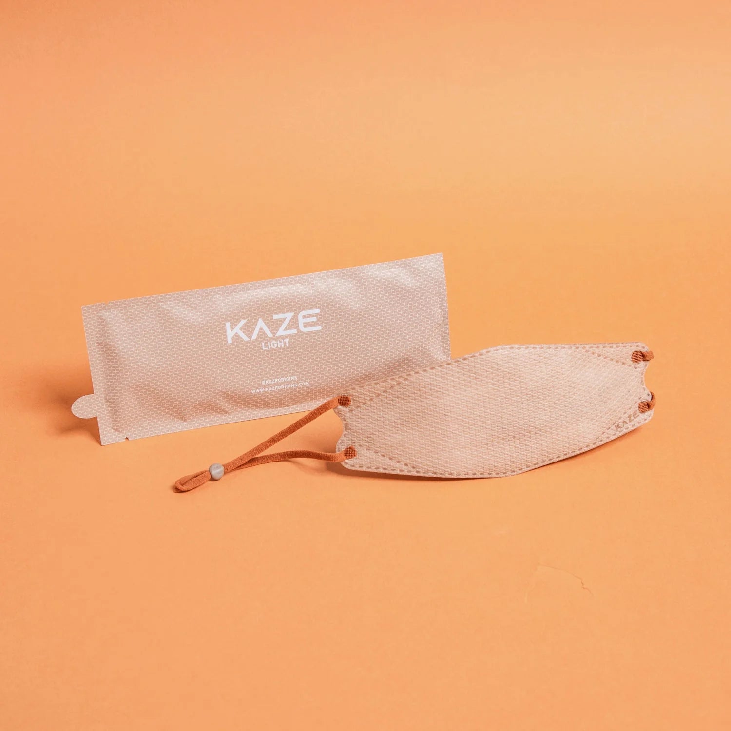 KAZE face mask with packaging on an orange background