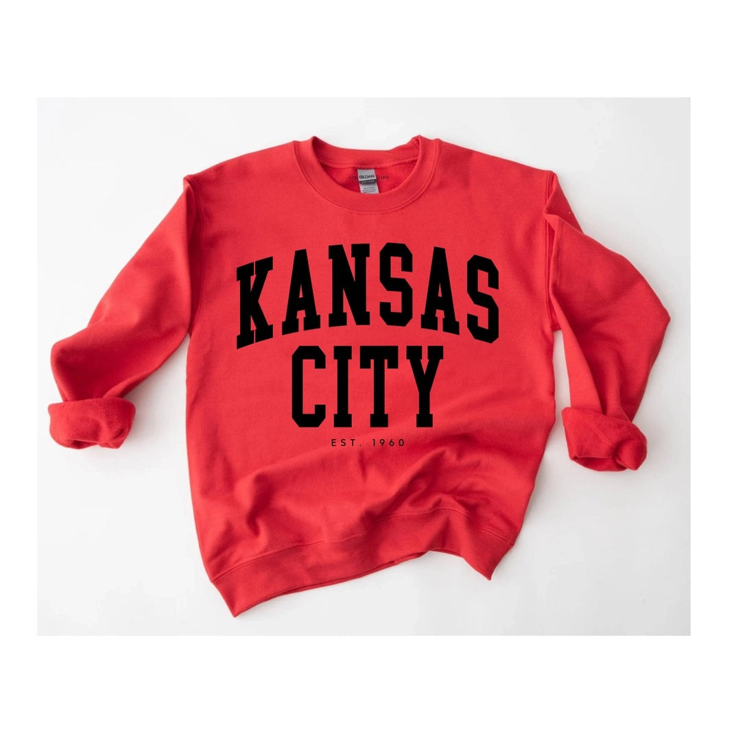 Red sweatshirt with 'Kansas City EST 1960' text on a white background