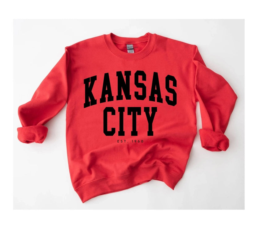Red sweatshirt with 'Kansas City EST 1960' text on a white background