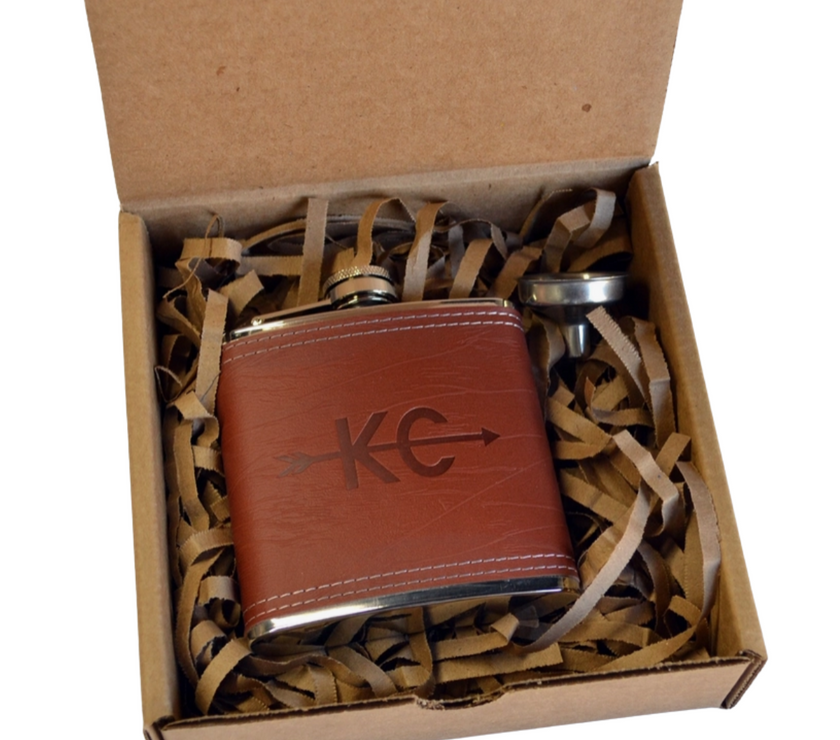 Brown leather flask with metal cap in a cardboard box with tissue paper